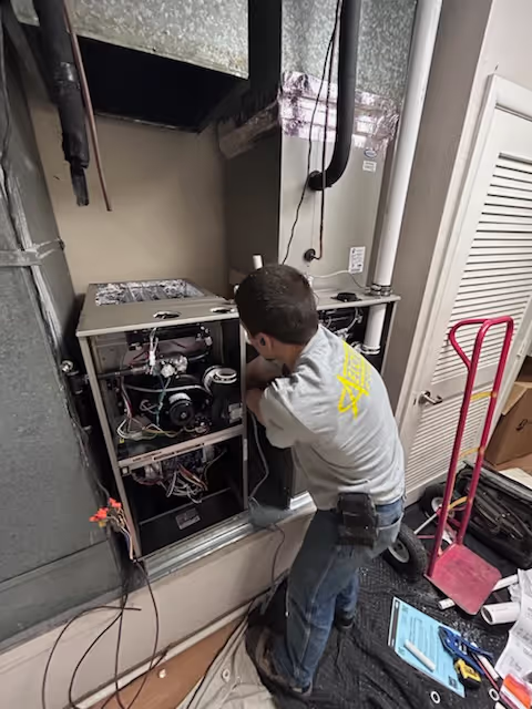 HVAC service technician working on indoor equipment