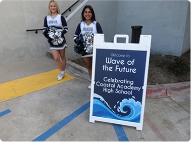 Person standing beside branded promotional display at outdoor event